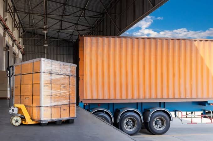 Container trailer at a New Jersey loading dock with palletized freight on a pallet jack